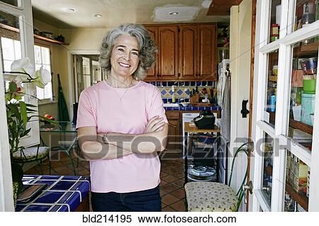 Stock Photography - Caucasian woman smiling in kitchen. Fotosearch