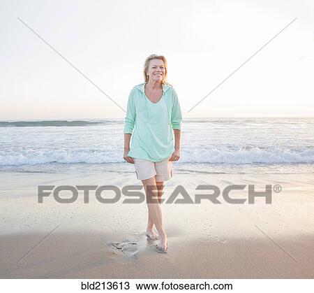 Stock Image - Caucasian woman smiling on beach. Fotosearch