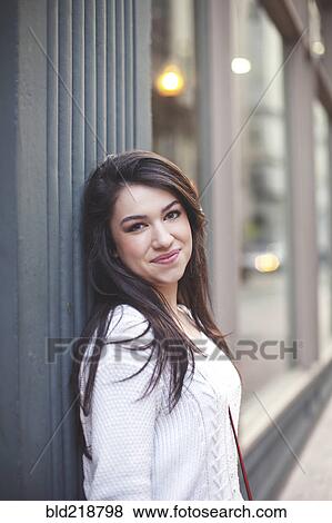 Stock Photo - Caucasian woman smiling on city sidewalk. Fotosearch