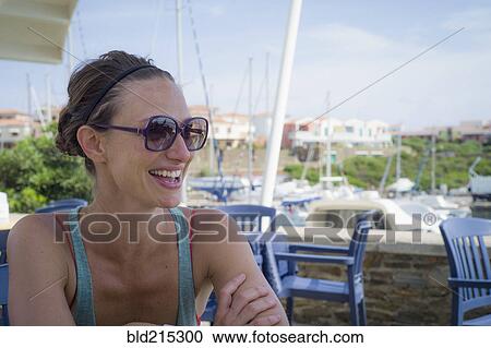 Stock Image - Caucasian woman smiling on restaurant patio. Fotosearch