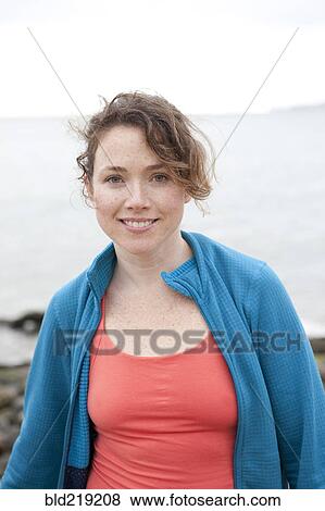Caucasian woman smiling on rocky beach View Large Photo Image Stock Photo - Caucasian woman smiling on rocky beach. Fotosearch