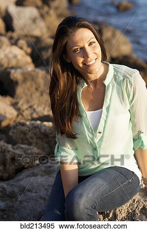 Caucasian woman smiling on rocky beach View Large Photo Image Stock Photography - Caucasian woman smiling on rocky beach. Fotosearch