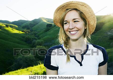 Stock Photo - Caucasian woman smiling on rural hilltop. Fotosearch