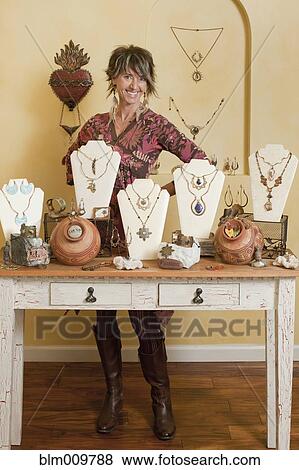 Caucasian woman standing by jewelry display View Large Photo Image Stock Photo - Caucasian woman standing by jewelry display. Fotosearch