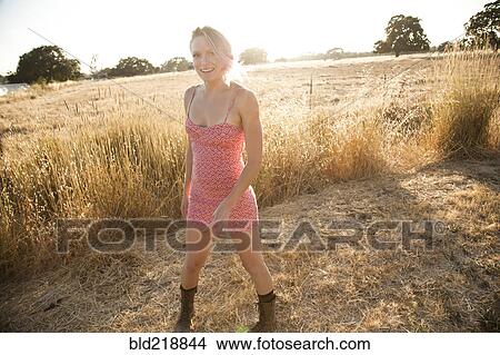 Picture - Caucasian woman standing in rural field. Fotosearch