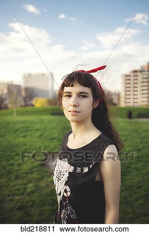 Stock Image - Caucasian woman standing in urban park. Fotosearch