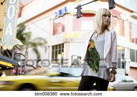 Stock Image - Caucasian woman standing on city street. Fotosearch