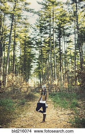 Picture - Caucasian woman standing on dirt path. Fotosearch