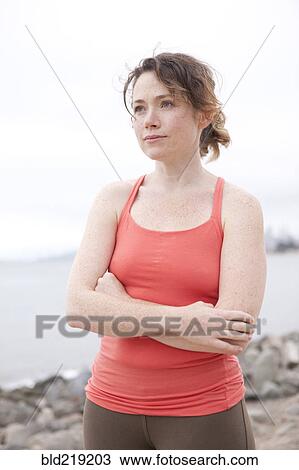 Caucasian woman standing on rocky beach View Large Photo Image Stock Image - Caucasian woman standing on rocky beach. Fotosearch
