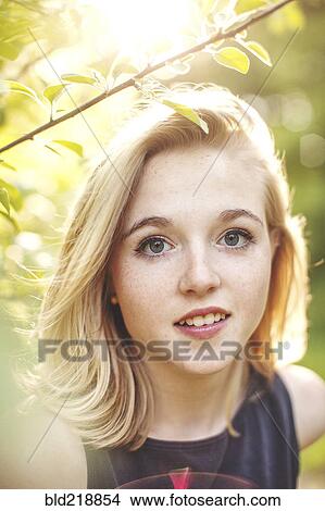 Picture - Caucasian woman standing under tree branches. Fotosearch
