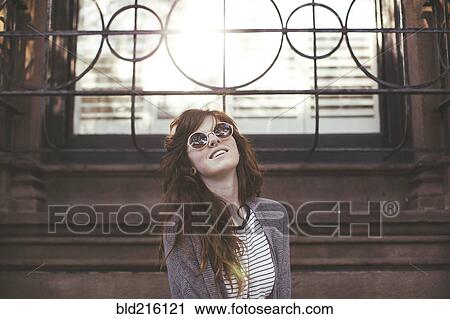 Stock Image - Caucasian woman standing under window. Fotosearch