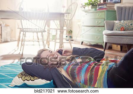 Caucasian woman talking on cell phone on floor View Large Photo Image Stock Image - Caucasian woman talking on cell phone on floor. Fotosearch