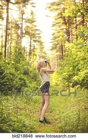 Caucasian woman using binoculars in forest View Large Photo Image Stock Photo - Caucasian woman using binoculars in forest. Fotosearch