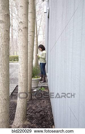 Stock Photo - Caucasian woman using cell phone outdoors. Fotosearch