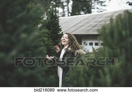 Stock Photo - Caucasian woman walking in Christmas tree lot. Fotosearch