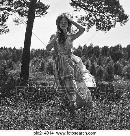 Picture - Caucasian woman walking in rural field. Fotosearch