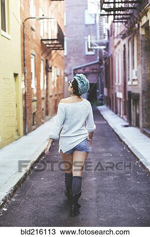 Caucasian woman walking in urban alleyway View Large Photo Image Stock Image - Caucasian woman walking in urban alleyway. Fotosearch