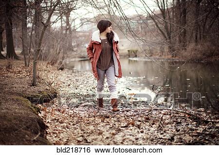 Stock Photograph - Caucasian woman walking near rural creek. Fotosearch
