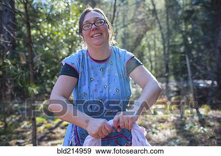 Stock Photo - Caucasian woman washing clothes in forest. Fotosearch