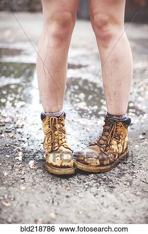 Stock Photograph - Caucasian woman wearing dirty boots. Fotosearch
