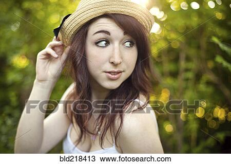 Stock Image - Caucasian woman wearing hat outdoors. Fotosearch