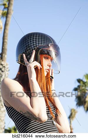Picture - Caucasian woman wearing motorcycle helmet. Fotosearch