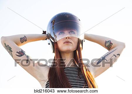 Stock Image - Caucasian woman wearing motorcycle helmet. Fotosearch