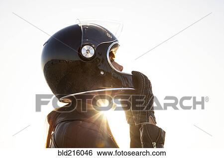 Stock Photograph - Caucasian woman wearing motorcycle helmet. Fotosearch