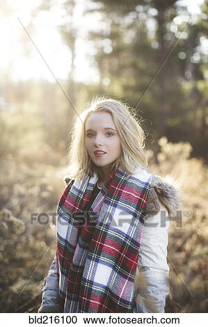 Stock Image - Caucasian woman wearing scarf in forest. Fotosearch
