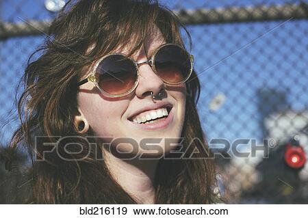 Caucasian woman wearing sunglasses at fence View Large Photo Image Stock Photo - Caucasian woman wearing sunglasses at fence. Fotosearch