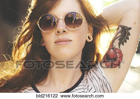 Stock Image - Caucasian woman wearing sunglasses outdoors. Fotosearch