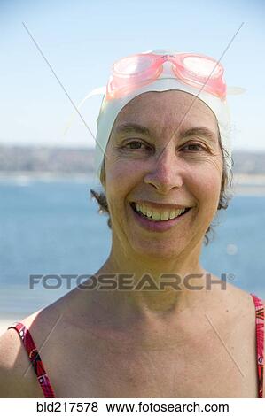 Stock Photo - Caucasian woman wearing swim cap and goggles. Fotosearch