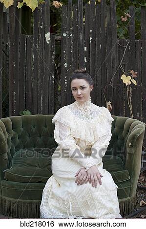 Caucasian woman wearing vintage gown on backyard sofa View Large Photo Image Stock Photograph - Caucasian woman wearing vintage gown on backyard sofa. Fotosearch