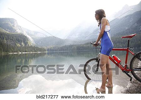 Caucasian woman with bicycle in remote lake View Large Photo Image Stock Photo - Caucasian woman with bicycle in remote lake. Fotosearch
