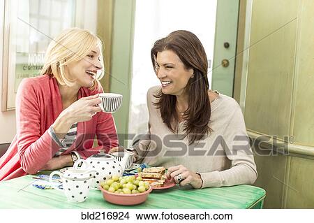 Picture - Caucasian women drinking tea and laughing. Fotosearch
