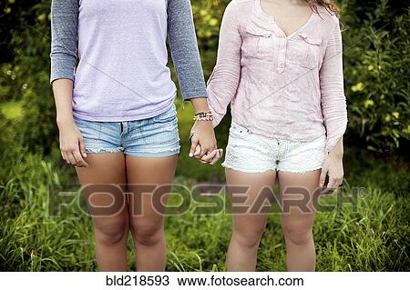Caucasian women holding hands in rural field View Large Photo Image Stock Image - Caucasian women holding hands in rural field. Fotosearch