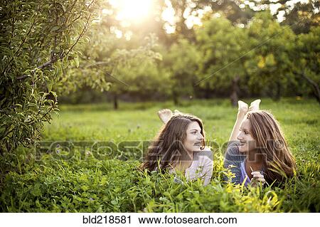 Caucasian women laying in rural field View Large Photo Image Stock Image - Caucasian women laying in rural field. Fotosearch