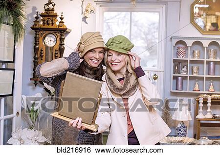 Caucasian women trying on hats in store View Large Photo Image Stock Photograph - Caucasian women trying on hats in store. Fotosearch
