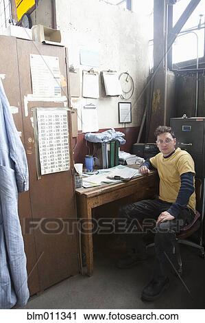 Stock Image - Caucasian worker sitting in office. Fotosearch