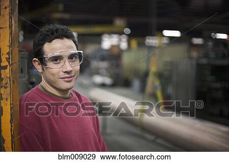 Stock Photo - Caucasian worker standing in factory. Fotosearch