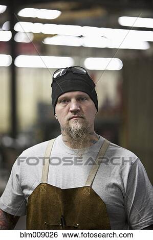 Caucasian worker standing in factory View Large Photo Image Stock Photograph - Caucasian worker standing in factory. Fotosearch