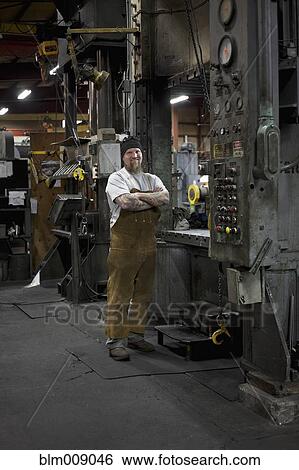 Caucasian worker standing in factory View Large Photo Image Stock Photograph - Caucasian worker standing in factory. Fotosearch