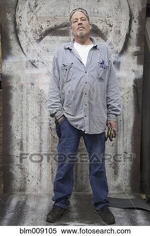 Stock Photography - Caucasian worker standing in factory. Fotosearch