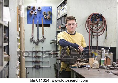 Picture - Caucasian worker standing in workshop. Fotosearch