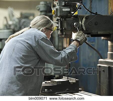 Caucasian worker using drill in factory View Large Photo Image Stock Image - Caucasian worker using drill in factory. Fotosearch