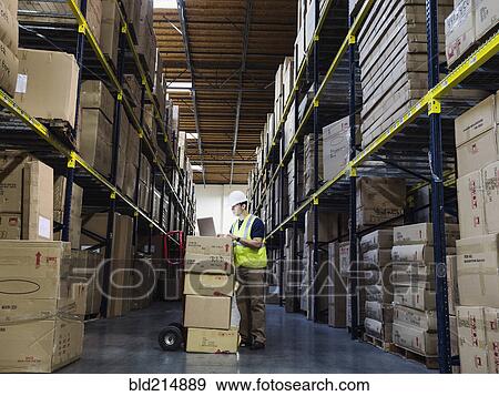 Caucasian worker using laptop in warehouse View Large Photo Image Stock Photo - Caucasian worker using laptop in warehouse. Fotosearch