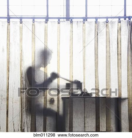 Stock Photo - Caucasian worker working behind plastic curtain. Fotosearch