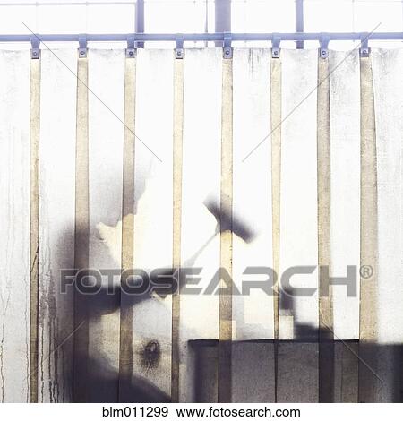 Stock Photo - Caucasian worker working behind plastic curtain. Fotosearch