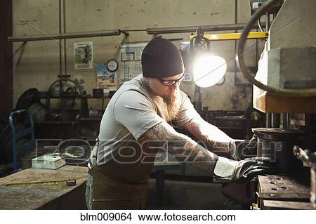 Picture - Caucasian worker working in factory. Fotosearch