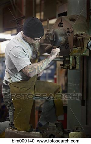 Caucasian worker working in factory View Large Photo Image Stock Image - Caucasian worker working in factory. Fotosearch